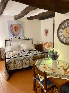 a bedroom with a bed and a table and a clock at La Tana del Grillo in Pitigliano