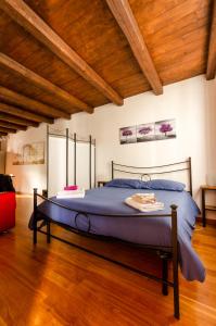 Cette chambre dispose d'un grand lit et de plafonds en bois. dans l'établissement La Morra Flats, à La Morra