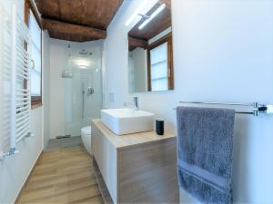 La salle de bains est pourvue d'un lavabo blanc et de toilettes. dans l'établissement La Morra Flats, à La Morra