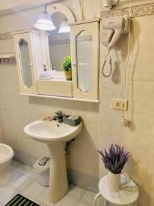 ein Bad mit einem Waschbecken und einem Spiegel in der Unterkunft La Tana del Grillo in Pitigliano