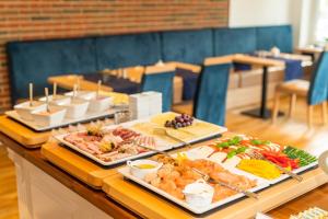 a buffet with many different types of food on a table at Hotel Das kleine Glück - Adults Only in Sankt Peter-Ording