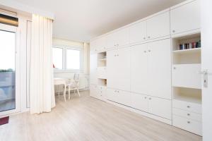 cocina blanca con armarios blancos y mesa en Haus Berolina Wohnung 500, en Dahme