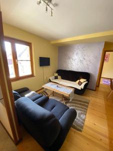 a living room with a couch and a table at Apartman Mijovic - Nova Varos in Nova Varoš