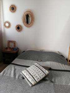 a bed with a pillow and three mirrors on the wall at COUP DE COEUR Studio in Rivedoux-Plage