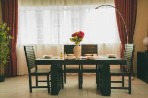 a dining room table with chairs and a vase with flowers on it at Two Continents Holiday Homes - Marina View 2 bedroom apartment -Free Airport Pick-up in Dubai