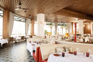 un ristorante con tavoli e sedie bianchi e finestre di The Cromwell Hotel & Casino a Las Vegas