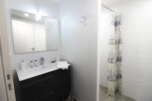 a bathroom with a sink and a mirror at Les Vagues avec Jacuzzi Privatif & Parking Privé in Sarlat-la-Canéda