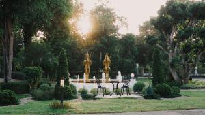 une table et des chaises dans un parc avec une fontaine dans l'établissement Luckswan Resort Chiang Rai - SHA Extra Plus, à Chiang Rai