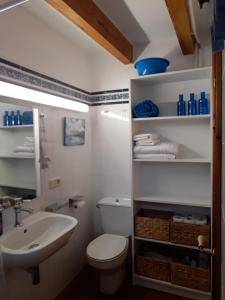 Un baño con un inodoro blanco y un lavabo. en Casa en Ferreries, en Ferreries