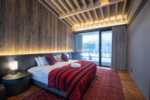 a bedroom with a bed and a large window at Gen Myo in Niseko