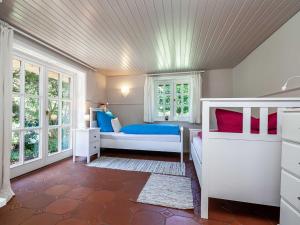 a bedroom with a bed and two windows at Ferienhaus REETselig mit Pool Sauna in Klein Barkau