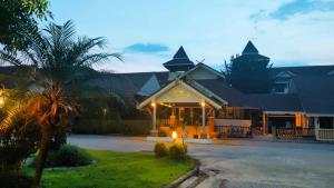 um resort com um edifício com uma palmeira em Luckswan Resort Chiang Rai - SHA Extra Plus em Chiang Rai