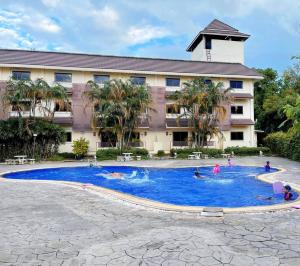 uma piscina em frente a um hotel com pessoas nele em Luckswan Resort Chiang Rai - SHA Extra Plus em Chiang Rai