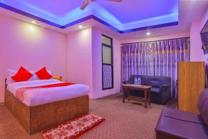 a bedroom with a bed and a couch and a tv at OYO 656 Hotel Shree Guru in Kathmandu
