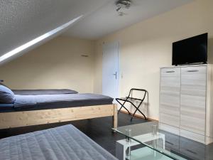 a bedroom with a bed and a tv on the wall at Ferienwohnung Schwalbe in Hagen