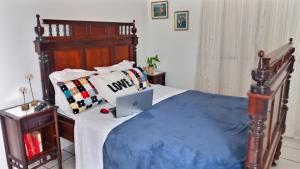 1 dormitorio con 1 cama con ordenador portátil en Vivenda Porto, conforto e estacionamento free no centro da cidade, en Porto Seguro