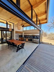 a large patio with a wooden table and chairs at Rixile Kruger Lodge in Skukuza