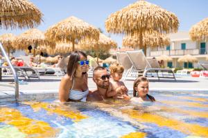 una famiglia in una piscina in un resort di Summer Time Family Resort a Bibione