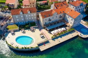 an aerial view of a large house with a swimming pool at Hotel Splendido in Kotor