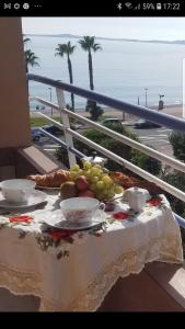 a table with plates of fruit on a balcony with the beach at La Plage in Cagnes-sur-Mer