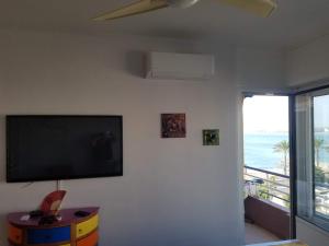 a living room with a flat screen tv on a wall at La Plage in Cagnes-sur-Mer