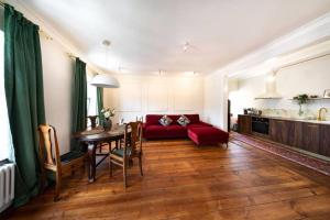 Una sala de estar con un sofá rojo y una mesa. en Old Town Prosta Toruń, en Toruń 5 fotos más