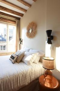 um quarto com uma cama com um relógio na parede em Les Nids Perchés - Place Notre-Dame em Mortagne-au-Perche
