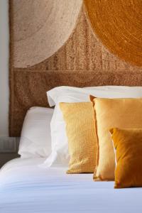 uma cama com lençóis brancos e almofadas em Slow Home Apartments em Valência