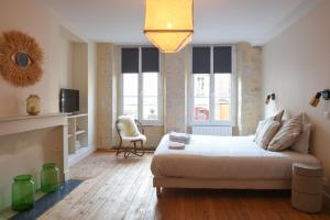 um quarto com uma cama e um sofá num quarto em Les Nids Perchés - Place Notre-Dame em Mortagne-au-Perche