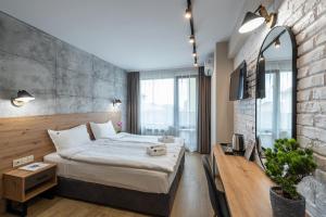 a bedroom with a large bed and a brick wall at Хотел Камъните in Burgas