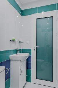 un bagno con lavandino e doccia in vetro di Bright Apartment in the Heart of the City by Flat Mаnager a Sofia