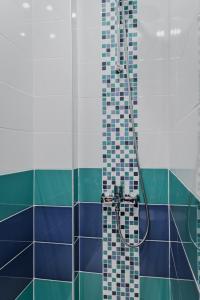 bagno con doccia e piastrelle blu e verdi di Bright Apartment in the Heart of the City by Flat Mаnager a Sofia Altre 9 foto