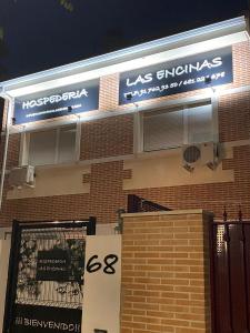 a sign on the side of a brick building at Hostal Las Encinas in Villaviciosa de Odón