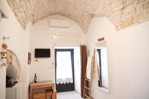Cette chambre est dotée de murs blancs et d'un plafond avec une porte. dans l'établissement Room 20 - Piccola Camera in pietra bianca, à Giovinazzo