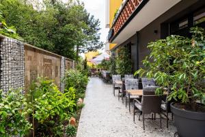an outdoor patio with tables and chairs and plants at Хотел Камъните in Burgas