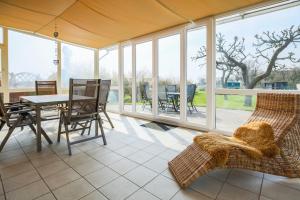 a screened in porch with a table and chairs at Ferienhof Büdlfarm - Bauers Haus in Sahrensdorf