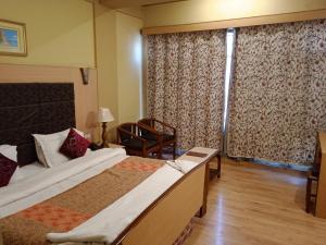 a hotel room with two beds and a window at Hotel New Mamta in Srinagar