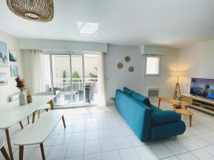 a living room with a blue couch and a table at Le Pontappart in Royan