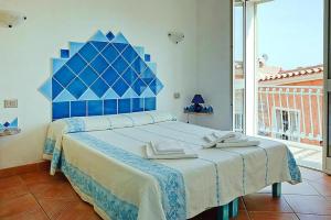 une chambre avec un grand lit et une tête de lit bleue dans l'établissement Residence Lu Nibareddu, Loiri, à Monte Petrosu