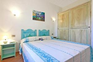 um quarto com uma cama azul num quarto em Residence Lu Nibareddu, Loiri em Monte Petrosu