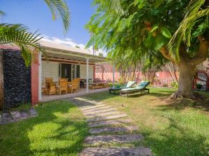 ein Haus mit einer Veranda mit einer Bank und einem Baum in der Unterkunft Bungalow Maspalomas Leticia in Maspalomas