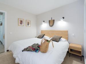 ein Schlafzimmer mit einem weißen Bett und einer Handtasche darauf in der Unterkunft Bungalow Maspalomas Leticia in Maspalomas + 30 Fotos