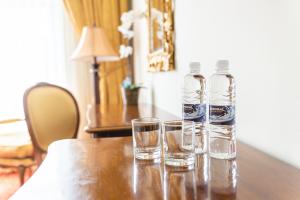 two bottles and glasses sitting on a wooden table at Casino & Hotel ADMIRAL Skofije in Zgornje Škofije