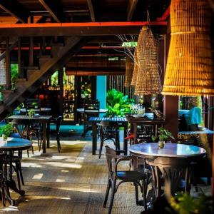 a restaurant with tables and chairs and lights at The Village House in Santubong