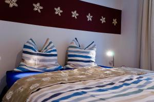łóżko z niebiesko-białymi poduszkami w obiekcie FEWO Sanddorn w mieście Hohen Wieschendorf