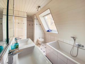 un bagno con vasca, lavandino e WC di Rheinloft 3 - Große Giebelwohnung mit Dachterrassen an der Rheinpromenade a Emmerich am Rhein Altre 36 foto