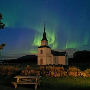 a church with the northern lights in the sky at Tranøya in Tranøya