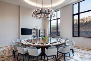 a dining room with a table and chairs and a chandelier at Holiday Inn Chengde Park View, an IHG Hotel in Chengde