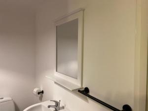 a bathroom with a mirror and a sink at 2-Bed Cottage in in Welsh Valley Nr Swansea in Swansea