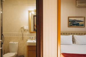 Un baño con una cama, un inodoro y un lavabo. en Готельна Ресторація "Україночка", en Krivoy Rog 39 fotos más